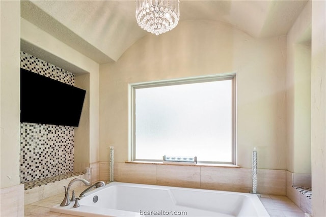 bathroom with a relaxing tiled tub, lofted ceiling, and a notable chandelier