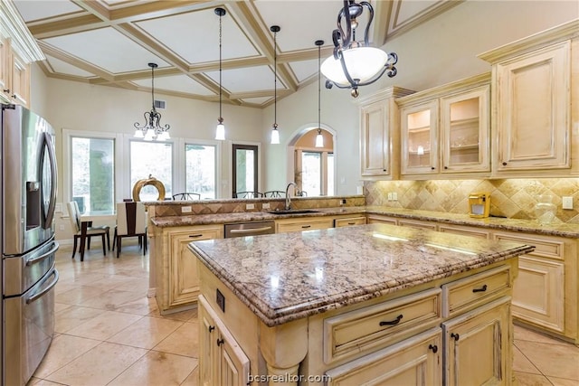 kitchen with kitchen peninsula, coffered ceiling, stainless steel appliances, sink, and a center island