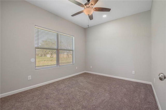 carpeted spare room featuring ceiling fan