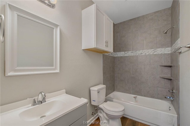 full bathroom featuring toilet, hardwood / wood-style floors, vanity, and tiled shower / bath combo