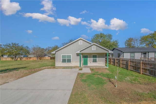 rear view of house featuring covered porch and a lawn