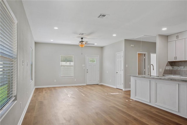 foyer entrance featuring light hardwood / wood-style floors, ceiling fan, and sink