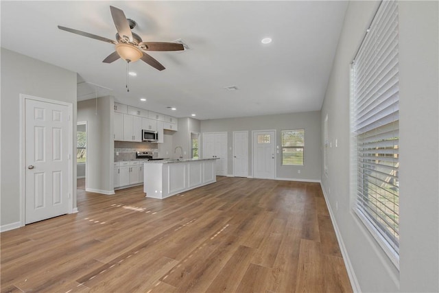 kitchen with ceiling fan, white cabinetry, appliances with stainless steel finishes, and light wood-type flooring