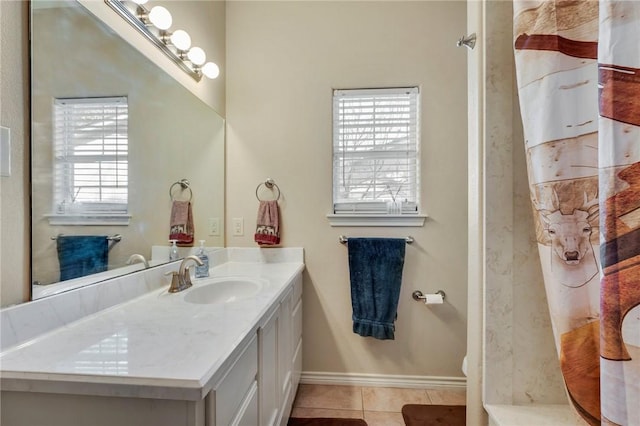 bathroom featuring curtained shower, tile patterned flooring, baseboards, and vanity