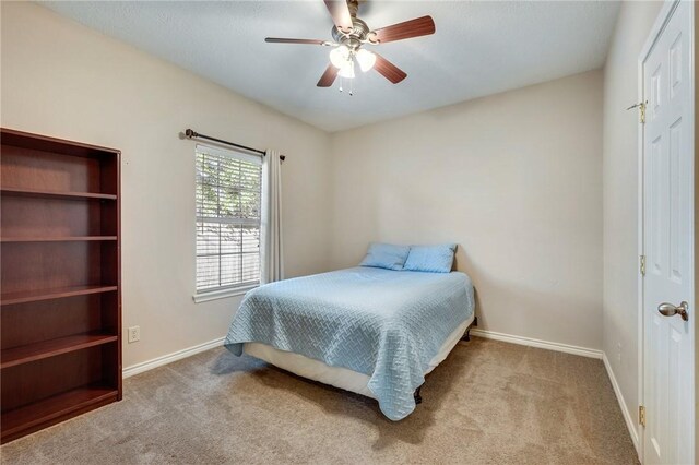 carpeted bedroom featuring ceiling fan and baseboards