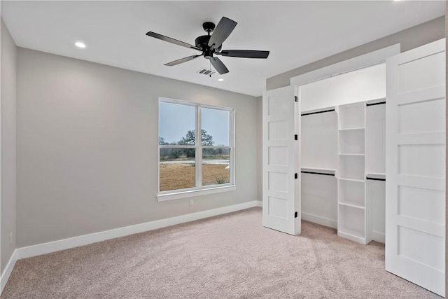 unfurnished bedroom with ceiling fan and light colored carpet