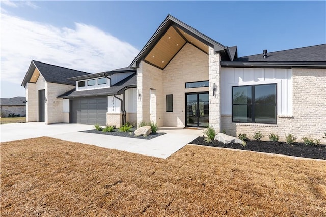 rear view of property featuring a garage and a lawn