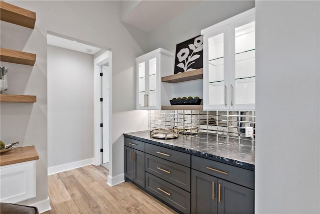 bar featuring white cabinetry, decorative backsplash, light hardwood / wood-style floors, and gray cabinetry