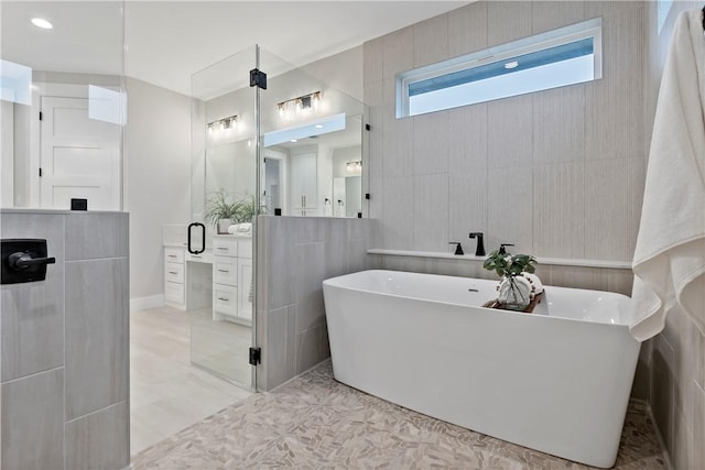 bathroom with vanity and independent shower and bath