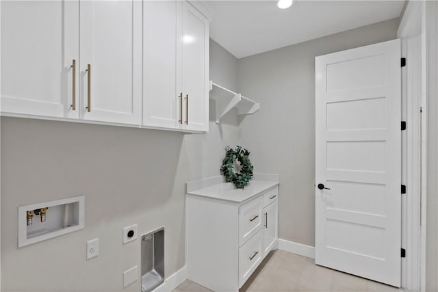 laundry room with cabinets, hookup for a washing machine, hookup for an electric dryer, and light tile patterned floors