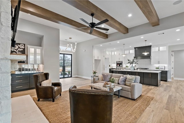 living room with ceiling fan, beam ceiling, and light hardwood / wood-style floors