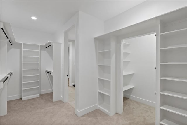 walk in closet featuring light carpet