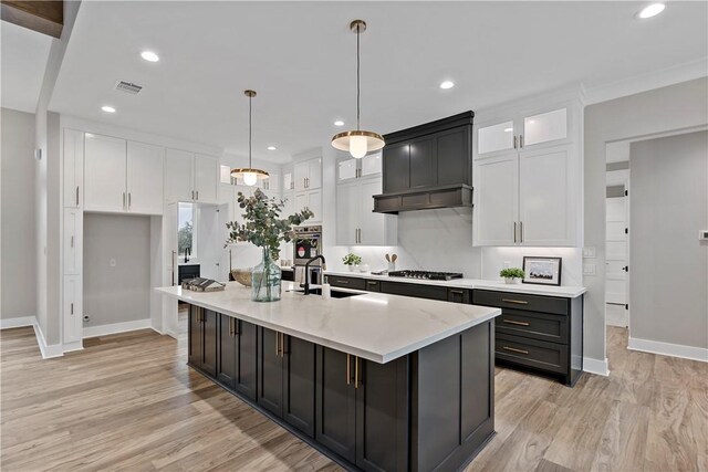 kitchen featuring white cabinetry, hanging light fixtures, double oven, and a spacious island