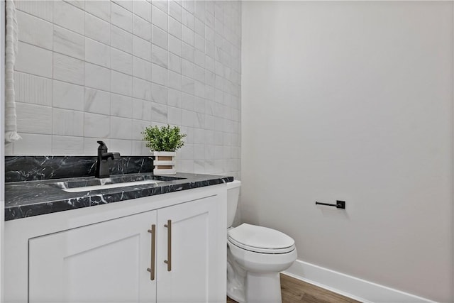 bathroom featuring vanity, wood-type flooring, tile walls, and toilet