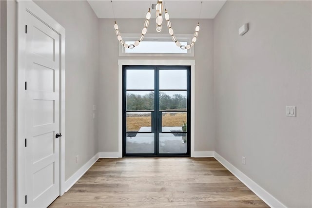 entryway with a chandelier and light wood-type flooring