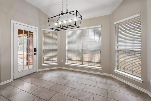 unfurnished dining area featuring tile patterned flooring, baseboards, and an inviting chandelier