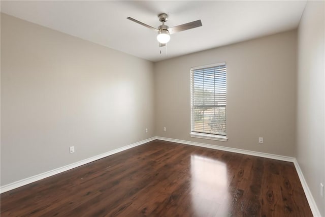 spare room featuring a ceiling fan, baseboards, and dark wood-style floors