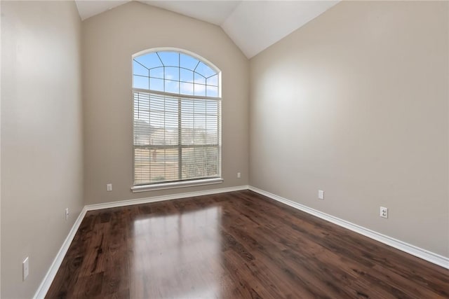 empty room with dark wood-style floors, lofted ceiling, and baseboards