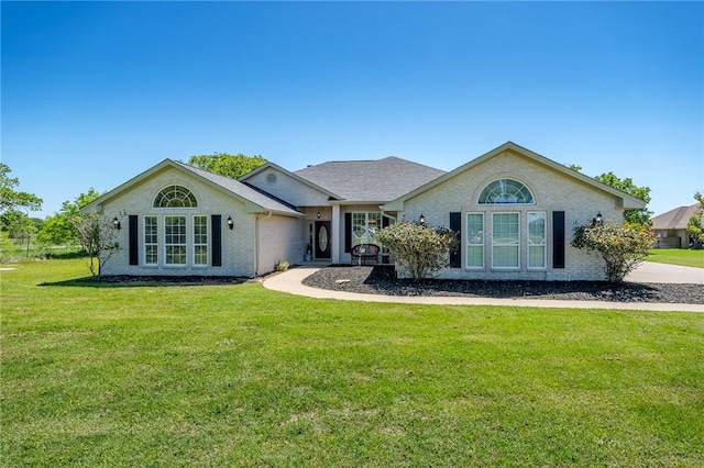 ranch-style home featuring brick siding and a front lawn