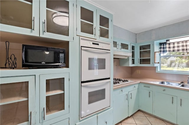 kitchen featuring sink, light tile patterned floors, and white appliances