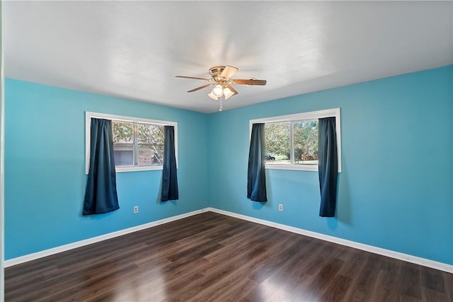 spare room with ceiling fan, plenty of natural light, and wood-type flooring