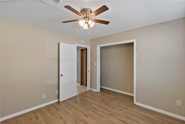 unfurnished bedroom featuring ceiling fan, light wood-type flooring, and a closet