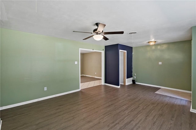 spare room with ceiling fan and dark wood-type flooring