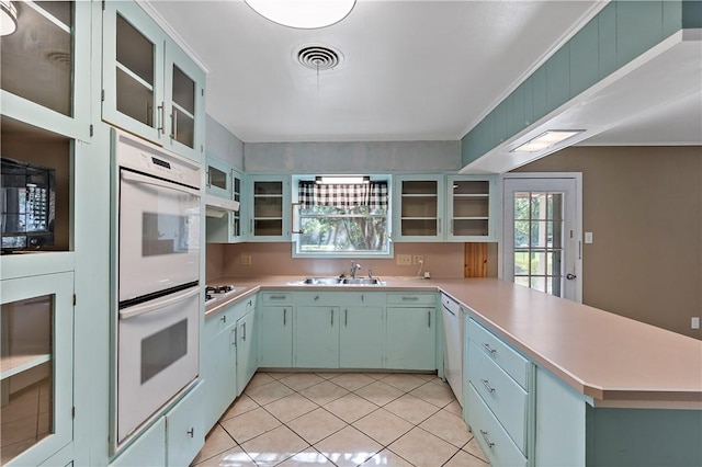 kitchen featuring kitchen peninsula, white appliances, light tile patterned flooring, and sink