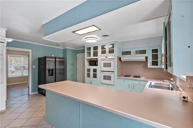 kitchen featuring kitchen peninsula, sink, light tile patterned flooring, and white appliances