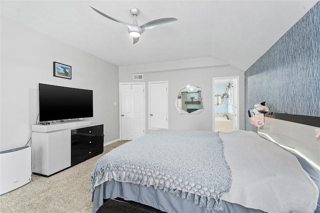 bedroom featuring connected bathroom, vaulted ceiling, ceiling fan, and carpet flooring