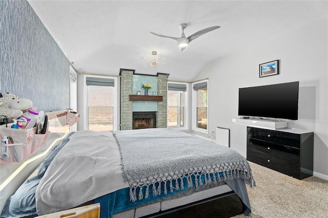 carpeted bedroom with lofted ceiling, a fireplace, and ceiling fan