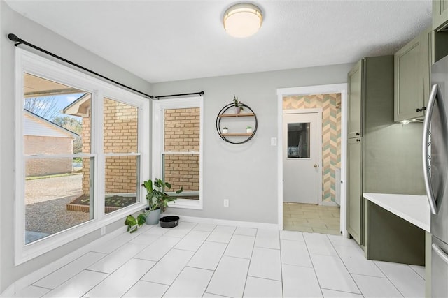 interior space with light tile patterned floors and green cabinetry