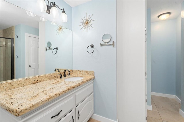 bathroom featuring a shower with door, vanity, and tile patterned floors