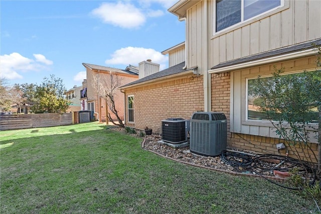 view of side of property featuring a lawn and central air condition unit