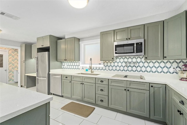 kitchen with sink, backsplash, stainless steel appliances, and light tile patterned floors