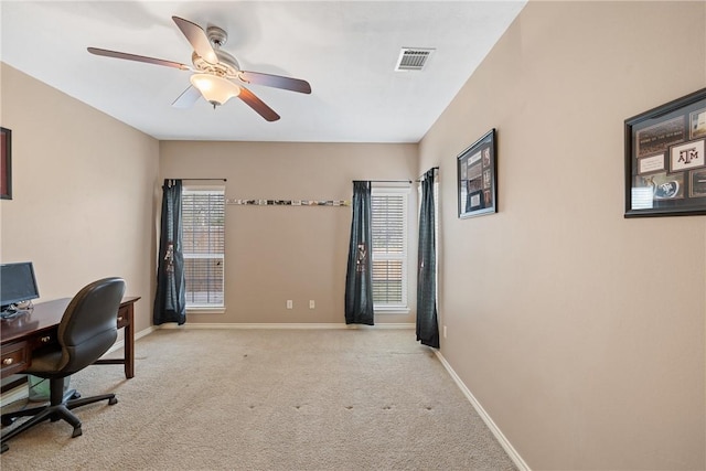 carpeted office space with ceiling fan and a healthy amount of sunlight