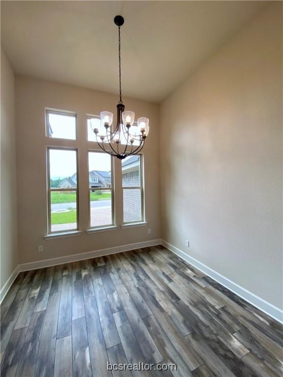 unfurnished dining area with a chandelier and dark hardwood / wood-style floors