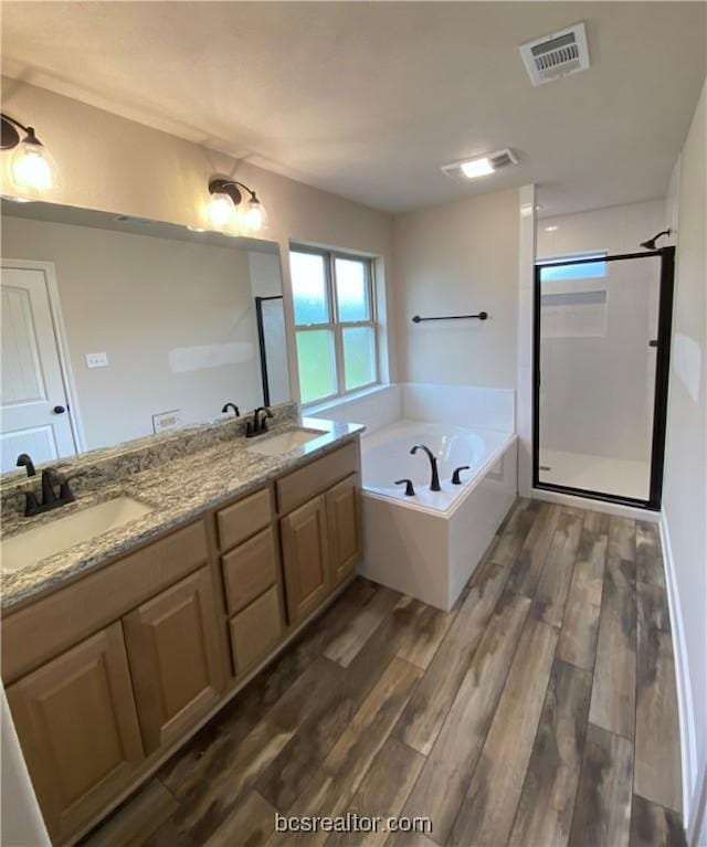 bathroom featuring wood-type flooring, vanity, and independent shower and bath