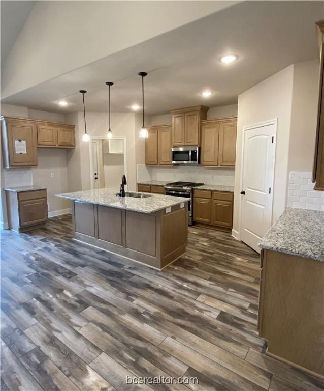 kitchen with light stone countertops, stainless steel appliances, dark wood-type flooring, and sink