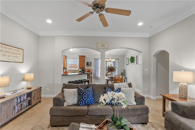 living area with light tile patterned flooring, recessed lighting, ornamental molding, and arched walkways