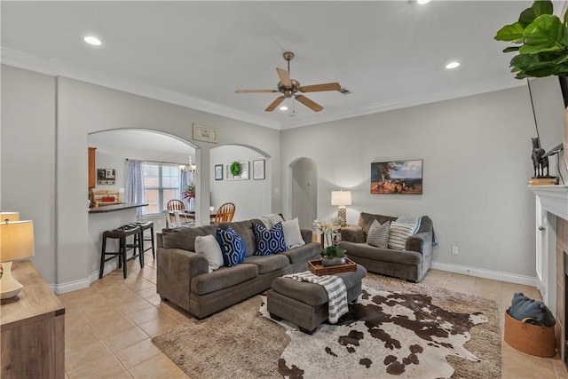living area with light tile patterned floors, arched walkways, a ceiling fan, and recessed lighting