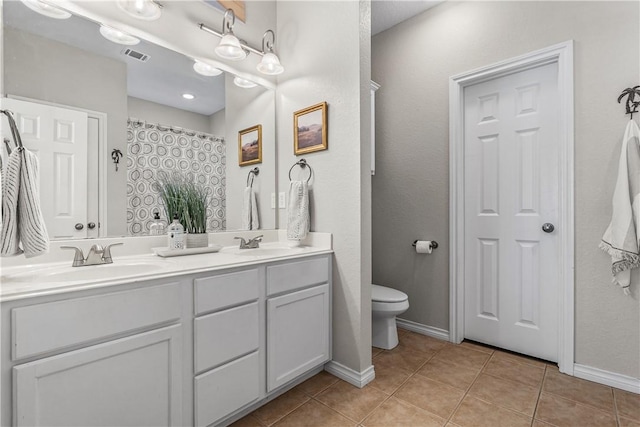 full bath featuring tile patterned floors, toilet, double vanity, and a sink