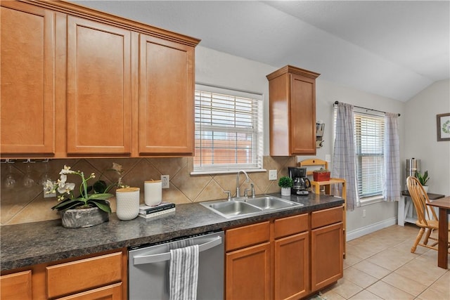 kitchen with tasteful backsplash, light tile patterned floors, dishwasher, a sink, and lofted ceiling