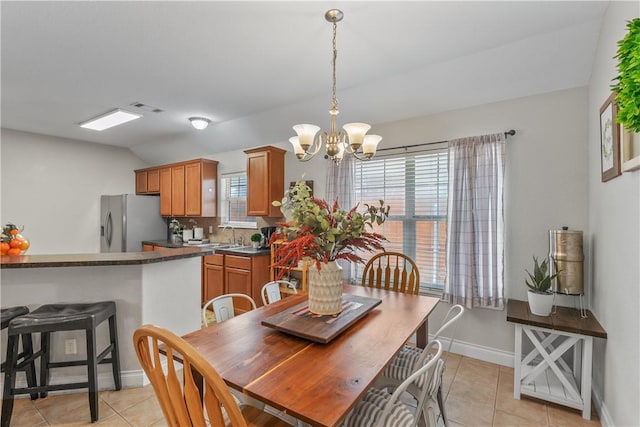 dining room featuring an inviting chandelier, light tile patterned floors, visible vents, vaulted ceiling, and baseboards