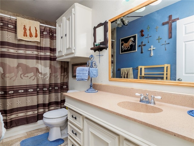 bathroom with tile patterned flooring, vanity, and toilet