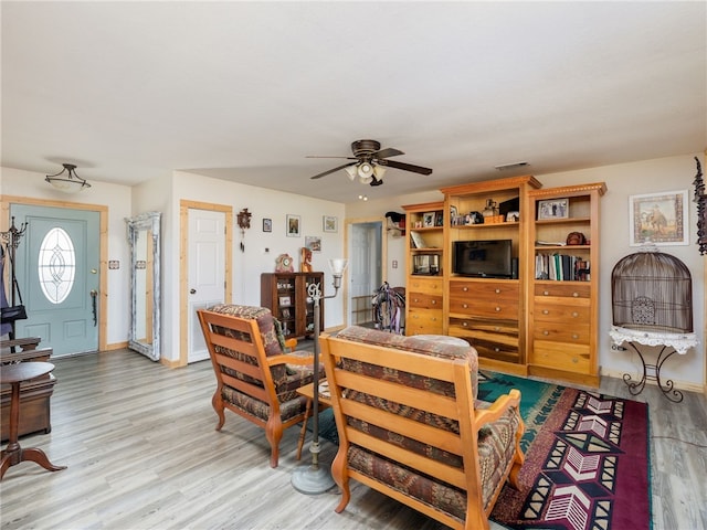 living room featuring ceiling fan and light hardwood / wood-style flooring