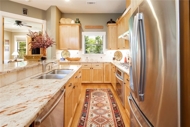 18140 Osage Trail Dr, College Station, TX 77845 - kitchen featuring stainless steel appliances, a sink, light brown cabinets, light wood finished floors, and under cabinet range hood