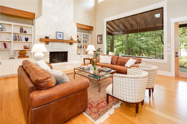 18140 Osage Trail Dr, College Station, TX 77845 - living area with light wood finished floors, built in shelves, a fireplace, baseboards, and a high ceiling