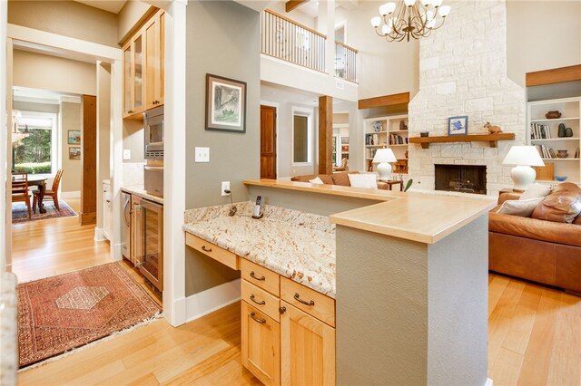 18140 Osage Trail Dr, College Station, TX 77845 - kitchen featuring open floor plan, light wood-style floors, a high ceiling, a chandelier, and wine cooler