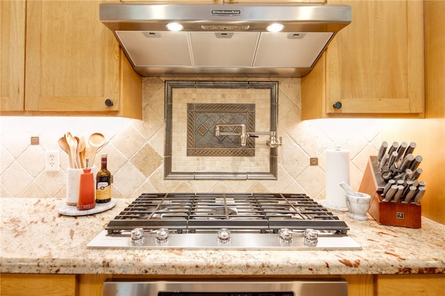 18140 Osage Trail Dr, College Station, TX 77845 - kitchen featuring under cabinet range hood, stainless steel gas cooktop, decorative backsplash, light stone counters, and light brown cabinets